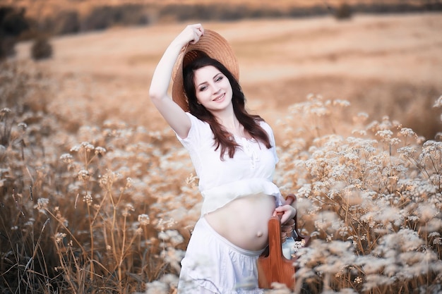 Pregnant woman in nature for a walk in the autumn