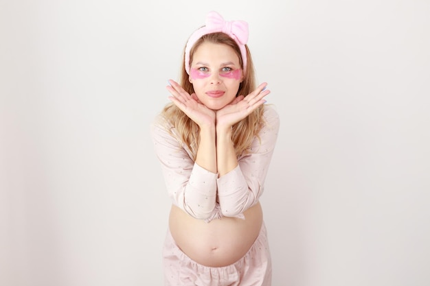 Pregnant woman in patches and pajamas on a white background