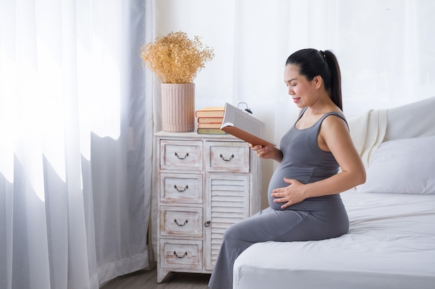 Pregnant woman reading a book for relaxation.