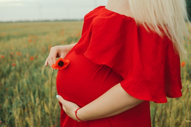 Pregnant woman in a red dress a woman waiting for a newborn