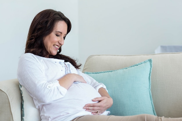 Pregnant woman resting on couch in living room