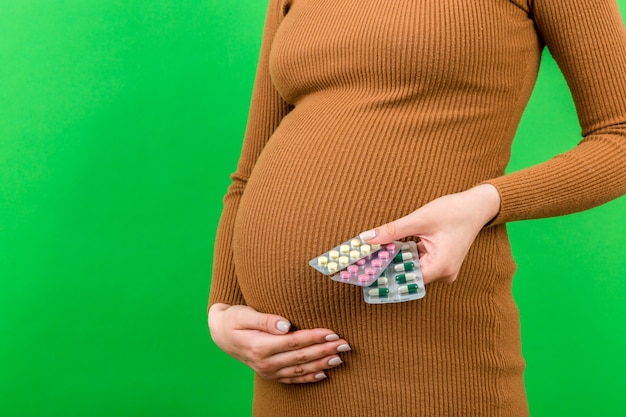 Pregnant woman showing blisters with pills