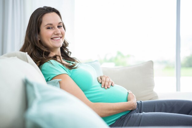 Pregnant woman sitting on couch at home