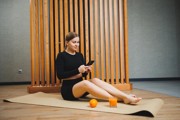 A pregnant woman in sportswear is sitting on a sports mat Pregnant woman doing sports healthy lifestyle of pregnant women