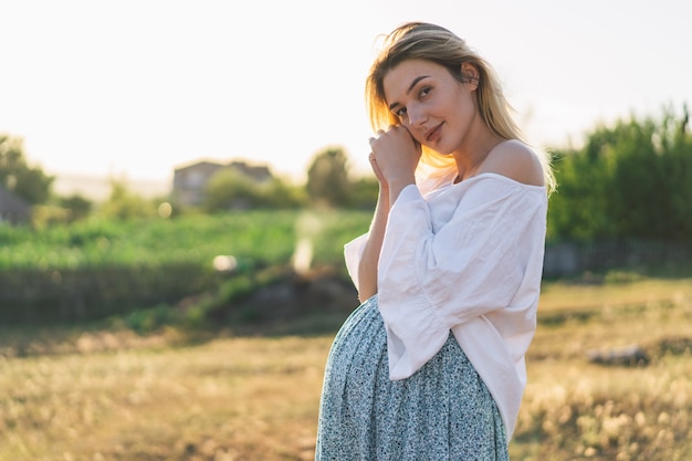 Pregnant woman standing in the field