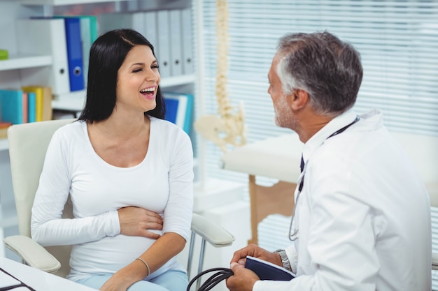 Pregnant woman talking to doctor in clinic