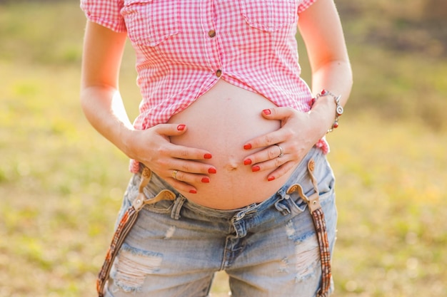 A pregnant woman trains yoga in a hero's pose caresses her belly Young happy future is resting thinking about her child and enjoying her future life Motherhood pregnancy