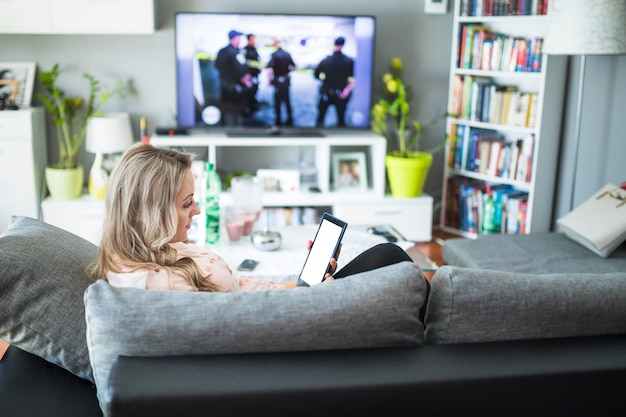 Pregnant woman using digital tablet in living room