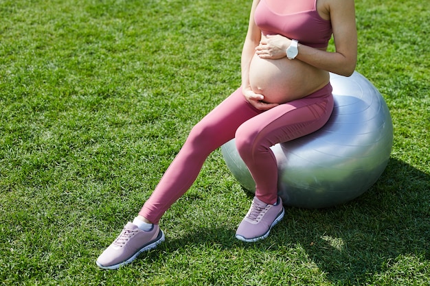 Pregnant woman using fitness ball for exercises