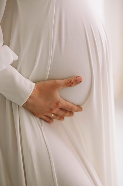 Photo pregnant woman white dress holding her belly close up photo of pregnant belly