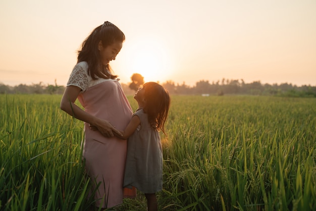 Pregnant woman with her daughter enjoying outdoor