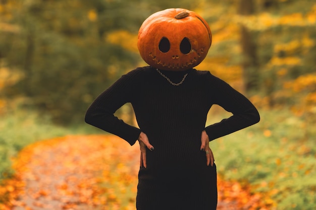 Photo pregnant woman with pumpkin head halloween costume