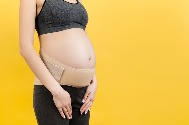 pregnant woman with supporting bandage against backache