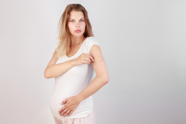 Pregnant woman with vaccine on white background