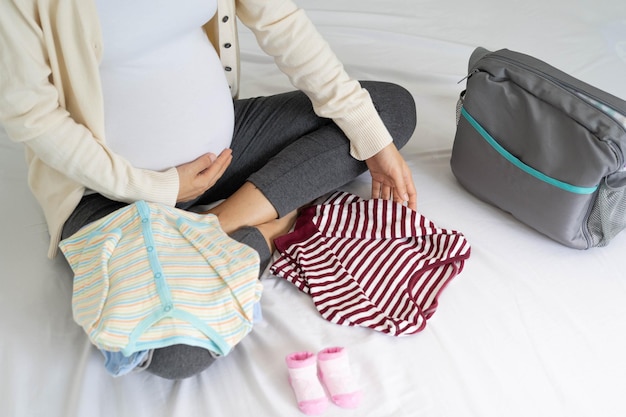 Pregnant women are happy to prepare baby clothes Packing bags for going to the hospital