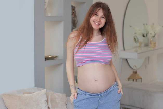 Pregnant young happy beautiful woman at home with big belly