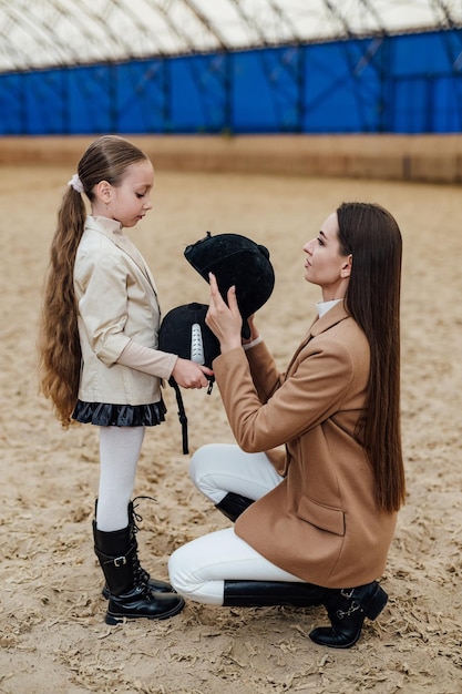 Prepairing for horse riding Cute girl in jockey cap