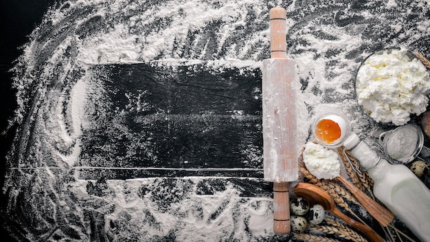 Photo preparation for baking cheese sour cream milk flour eggs on a black wooden background top view free space