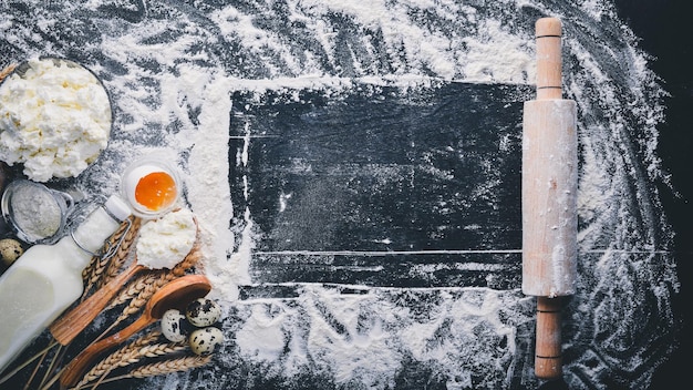 Preparation for baking cheese sour cream milk flour eggs On a black wooden background Top view Free space