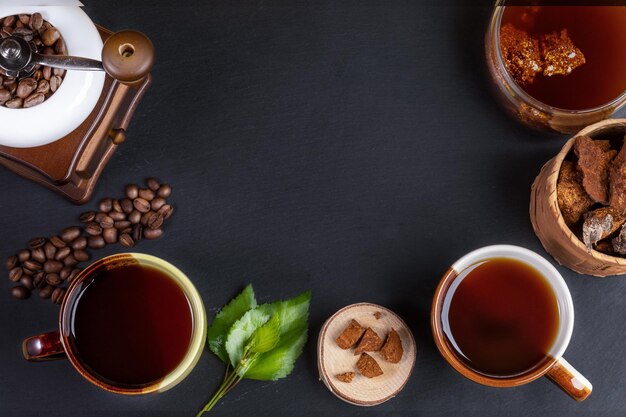 Preparation Chaga mushroom coffee Cups jar with chaga drink coffee grinder chaga pieces and coffee grains on black