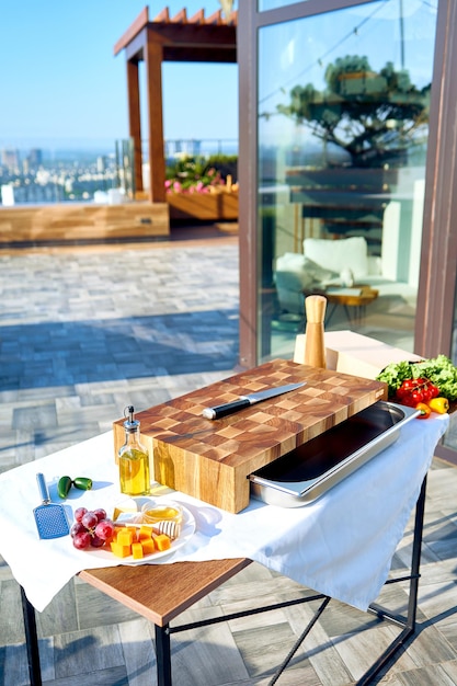 Preparation for dinner on the summer terrace. Image of a divider board with products.