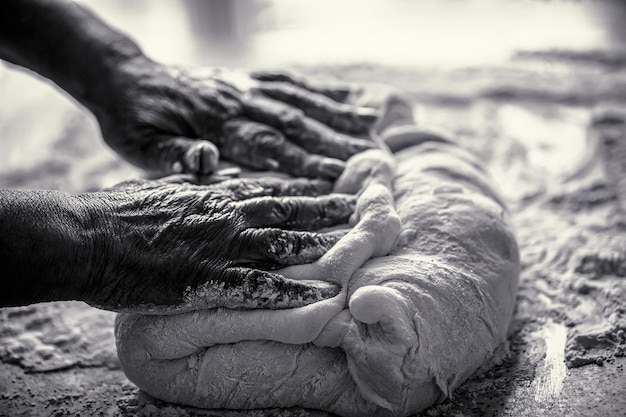 Preparation doughs Preparation doughs women's hands Making dough by male hands at bakery Food concept Black and white