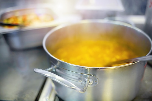 Preparation of the first course in the dining room Soup or chowder is cooked in an aluminum pot on an electric stove