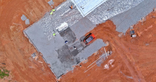 Preparation for pouring concrete with excavator bucket working in leveling gravel the building foundation