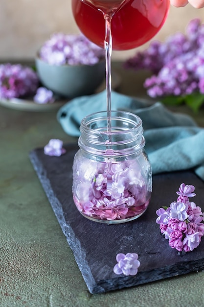 Preparation of syrup from the lilac flowers Glass jar of homemade lilac syrup