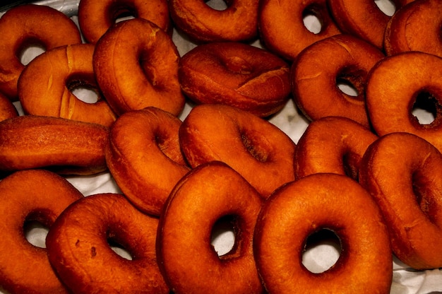 Preparation of traditional donuts freshly fried and waiting to be syruped