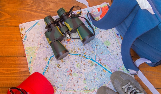 The preparation for the trip travel backpack binoculars camera map on wooden background