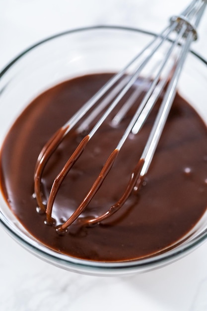 Preparing chocolate ganache in a glass mixing bowl.