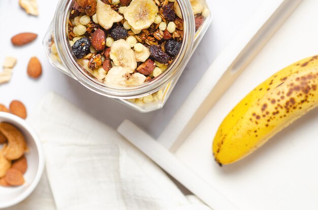 Preparing a healthy breakfast with homemade granola in a glass jar top view