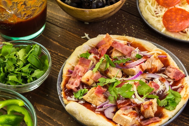 Preparing individual pizzas from pizza bar.