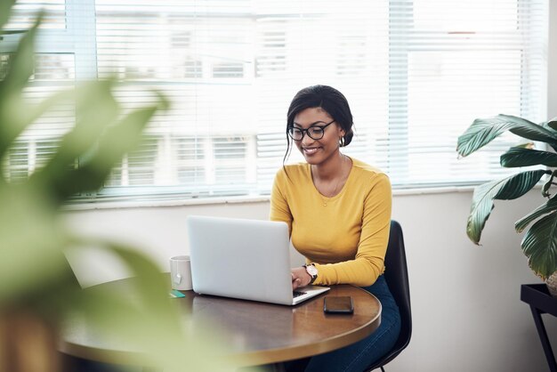 Preparing my next blog post Shot of an attractive young woman sitting alone at home and using her laptop