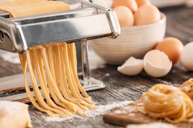 Preparing of pasta with machine on kitchen table