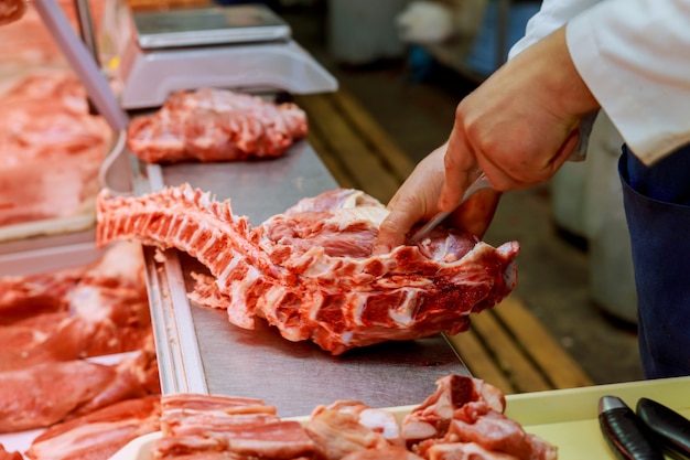 Preparing on shop butcher cutting meat at counter in butchery