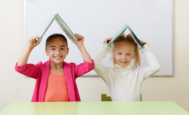 Preschool children playing with books sitting at a table