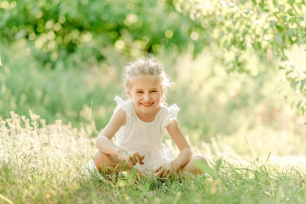 Preschool girl sitting on the grass