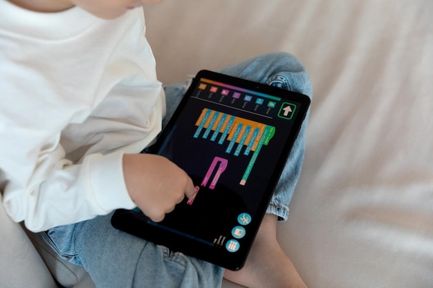 A preschool kid programmer coding at tablet pc, uses machine language