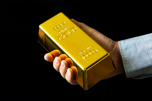 Present 1000 g of fine gold bars a man holds gold on a black background