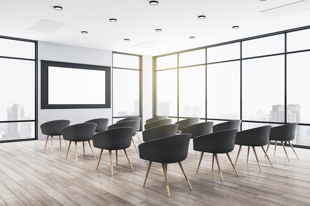 Presentation auditorium with empty white screen and panoramic city view