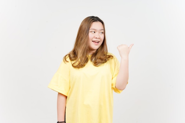 Presenting and Pointing Side Product Using Thumb of Beautiful Asian Woman wearing yellow TShirt