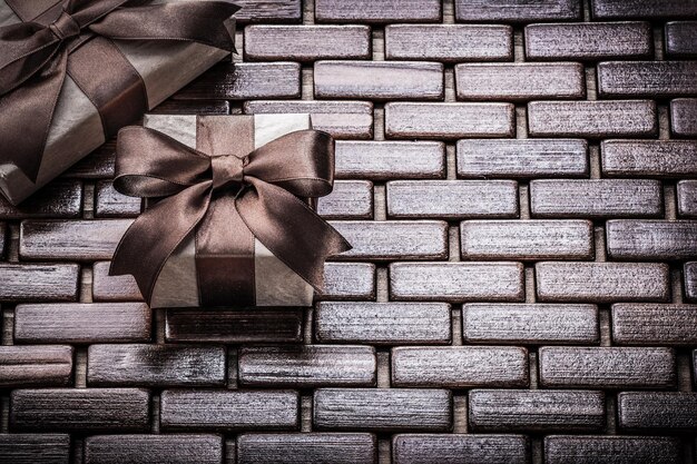 Presents wrapped with tied ribbons on wooden mat holidays concept