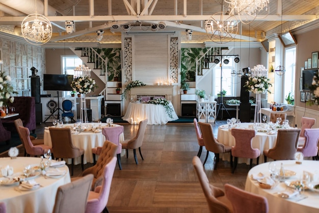 The presidium of the newlyweds in the banquet hall of the restaurant is decorated with candles and green plants wisteria hangs from the ceiling