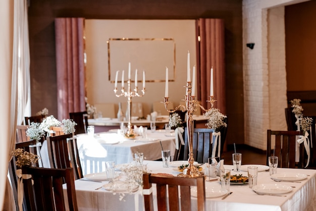 the presidium of the newlyweds in the banquet hall of the restaurant is decorated with candles