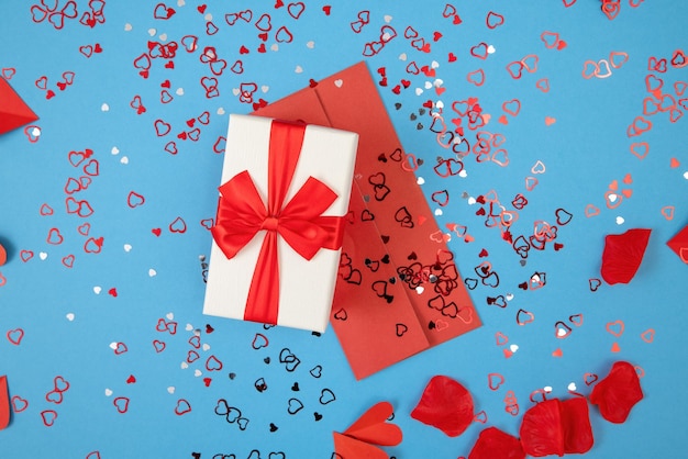 Presnet with envelope lying on blue background with glitters around