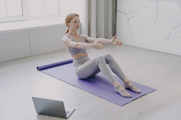 Press exercise and pilates at home Video lessons on laptop Concept of distance fitness classes