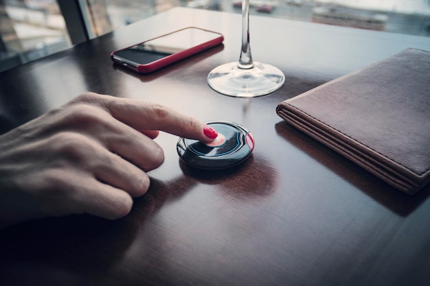 Pressing the buzzer Female hand finger presses the button to call the waiter in the restaurant to pay for food for dinner