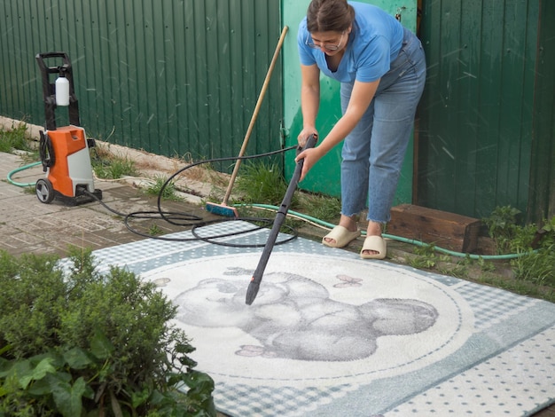 Pressure washable carpet Carpet cleaning with a professional spray a girl washes carpets